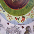 Load image into Gallery viewer, Close-up of a decorative astrology or zodiac-themed print showing a green band with a deer and strawberry motifs, red strawberries labeled 'Strawberry Moon,' and part of a light blue section with illustrated figures and symbols.
